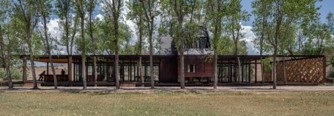 glass and steel home surrounded by trees