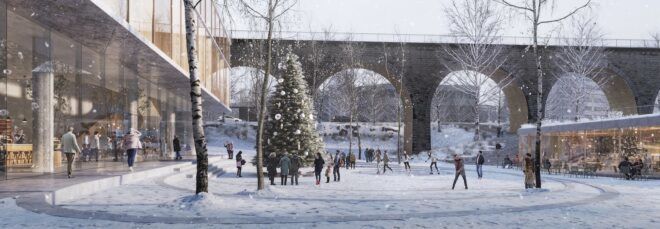 A winter landscape near a building with a connecting bridge with archways for people to walk through.