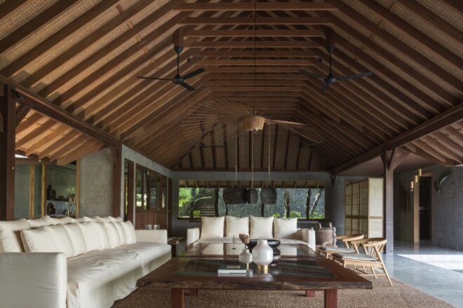 two large white sofas under pitched wood roof