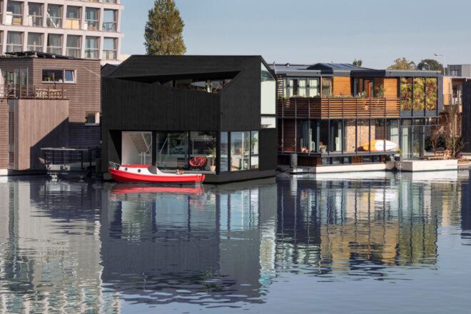 black home floating on a canal