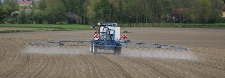 Tractor spraying pesticides on field