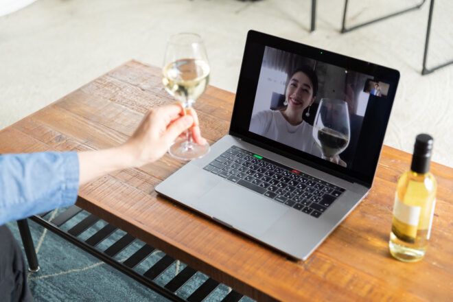 two people having wine while talking over a video call