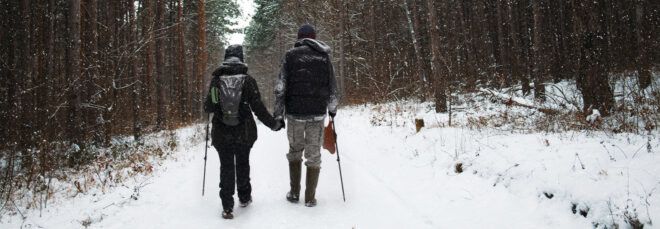two people hiking in the snowy woods