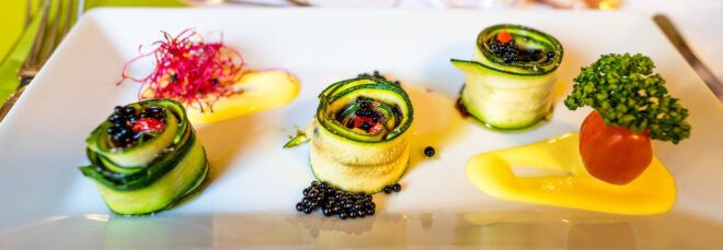 vegan zucchini rolls artfully arranged on a plate