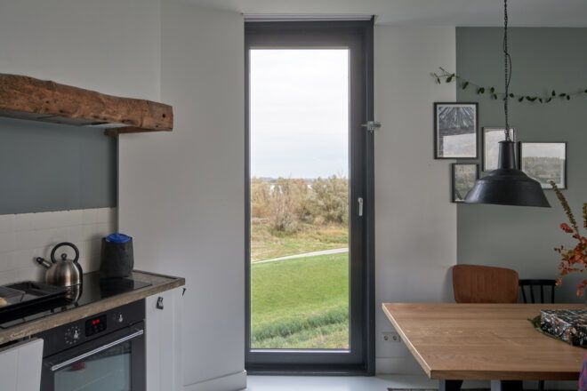 kitchen with tall, narrow window overlooking a polder landscape
