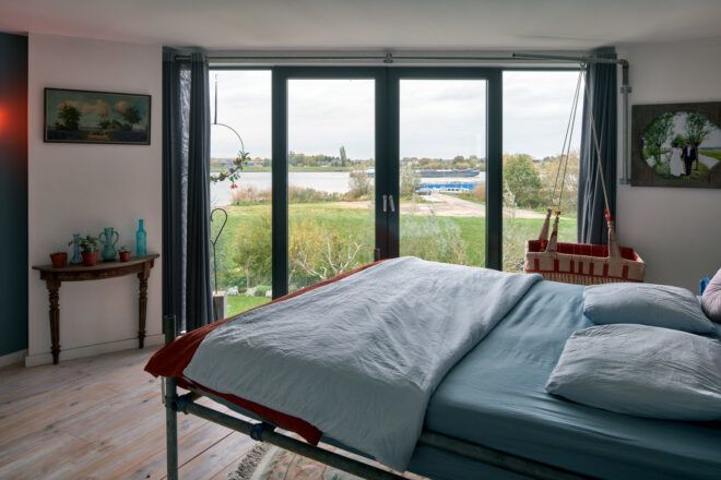 large blue bed facing a wall of glass