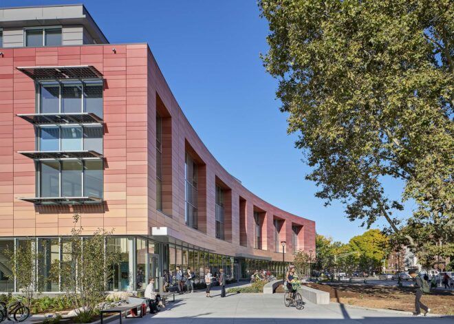 A building with a red facade that curves along a walkway.