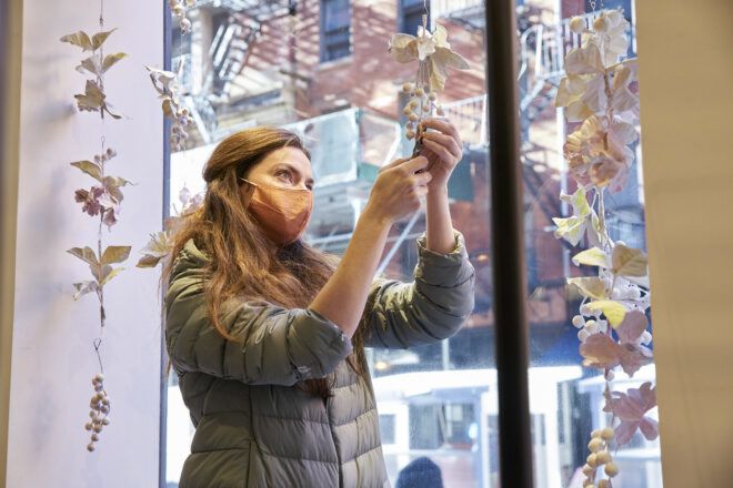 Artist Kim Markel wearing a face mask and working on an art display.