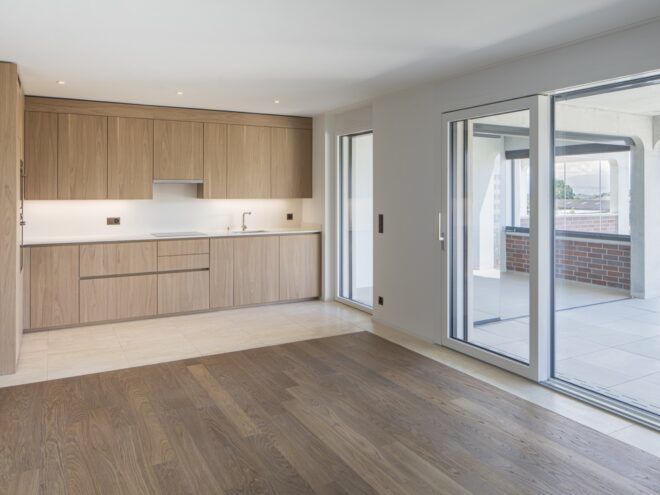 The interior of an empty apartment unit with light-colored wood accents and white paint.