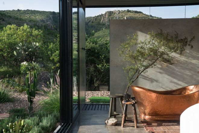 copper bathtub near wall of glass