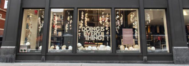 A streetview of a window display that reads "doing is everything."