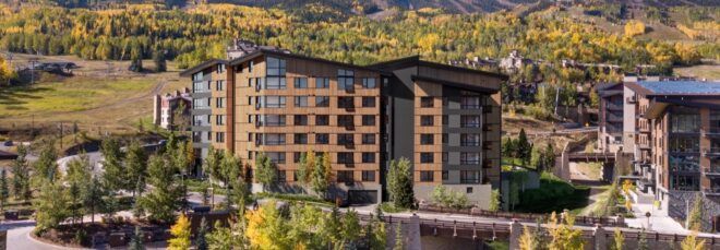 brown condo building surrounded by mountains