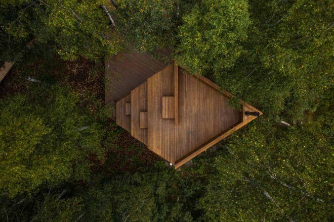 aerial view of diamond-shaped wood cabin in a forest