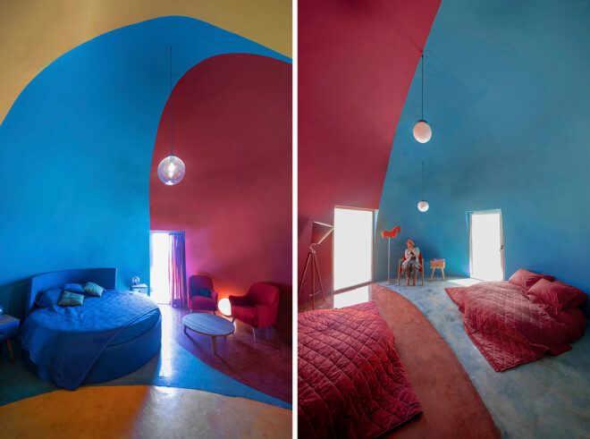 red, blue and yellow dome interior with blue sofa and red beds