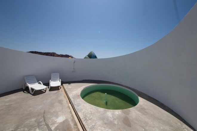 small round hot tub and lounge chairs on a roof patio