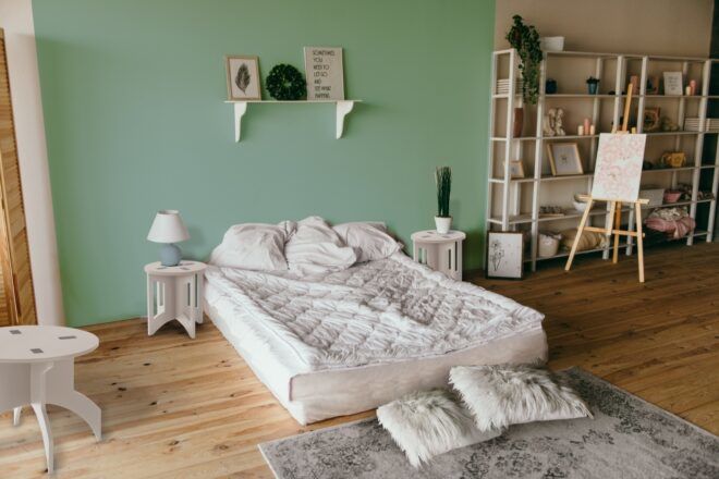 two small raw wood end tables on either side of a bed
