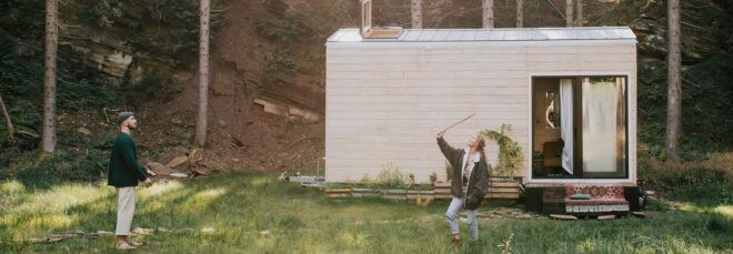 couple playing a game together outside their wooden tiny home