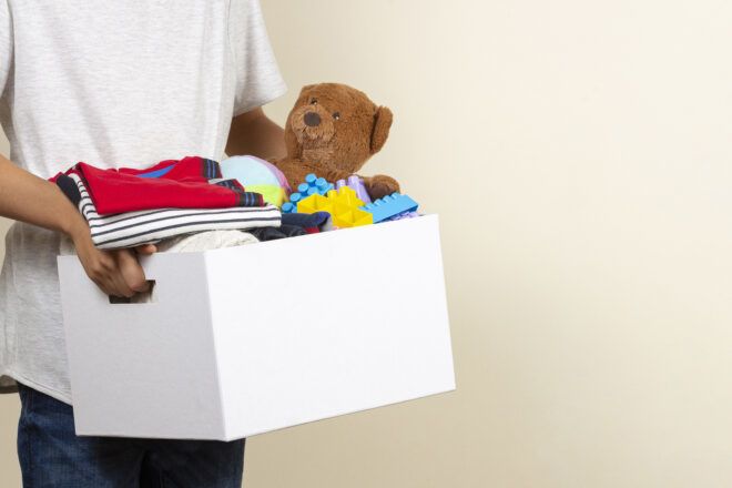 kid carrying box of old, gently used toys