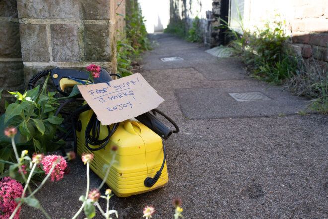 yellow power-washer with "For Free" sign attached sitting on a sidewalk
