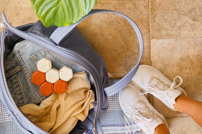 cream and orange travel containers in a large blue purse