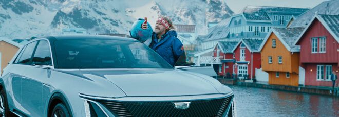 Actor Will Ferrell standing beside an electric vehicle