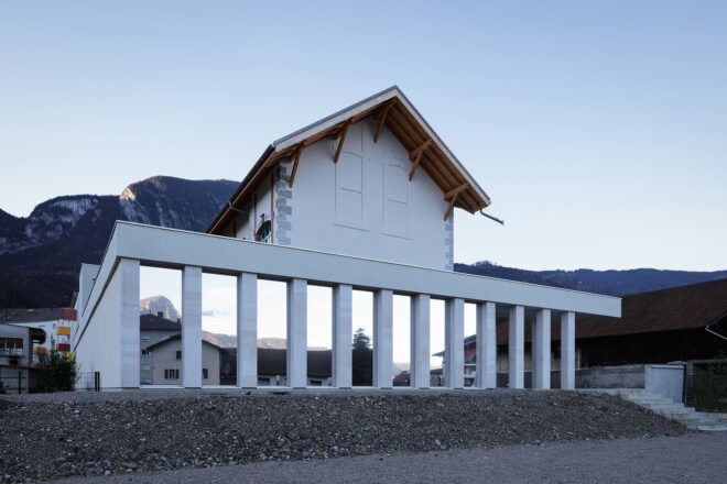 white building with gable roof and reflective facade panels