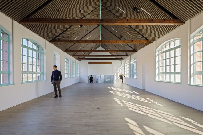 long white room with pitched ceiling and exposed structural beams