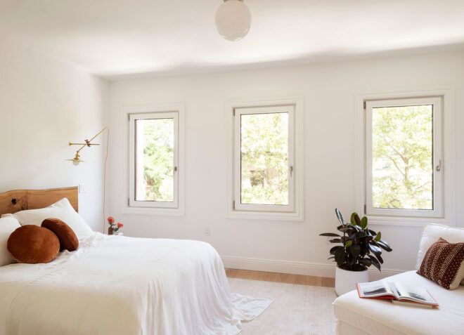 white bed and white lounge chair in white room