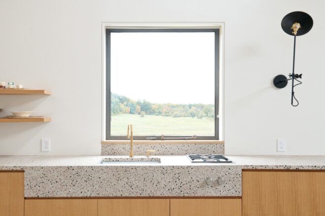 A square window in front of a countertop sink.