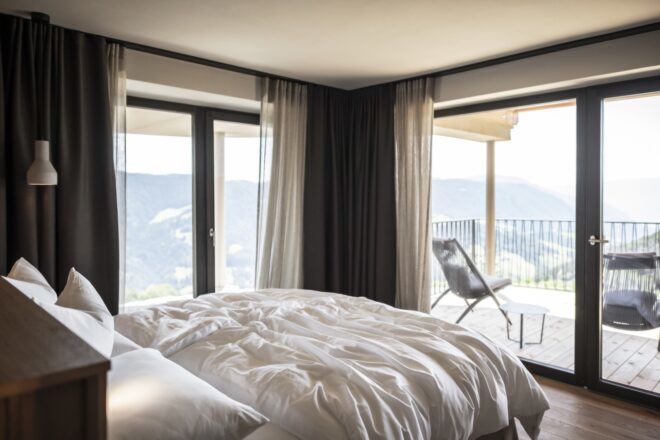 fluffy white bed facing glass walls