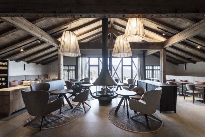 comfy chairs and round tables facing wall of glass