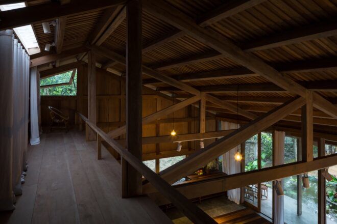 A wooden loft with a small window and wood beams.