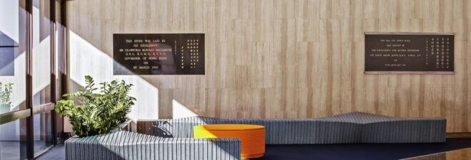 Two blue-gray benches with a round, orange piece of furniture between them.