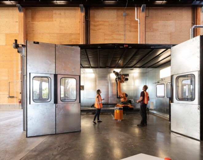 people working with a robot in a metal-lined room