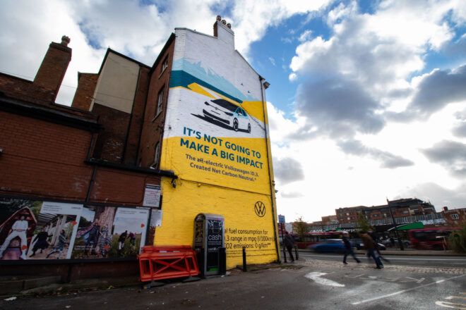 A large painted VW ad on the side of a building.