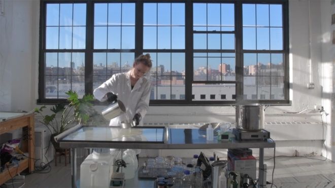 person pouring liquid in a lab setting