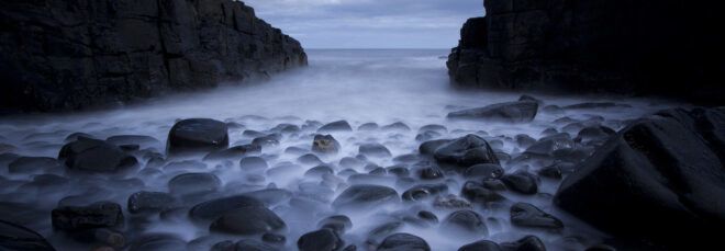 Rocks by the coast, covered in mist.