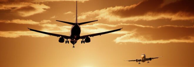 two planes flying at sunset