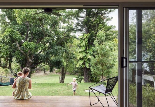 Open sliding glass doors looking out at the green yard where a child plays.