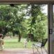 Open sliding glass doors looking out at the green yard where a child plays.