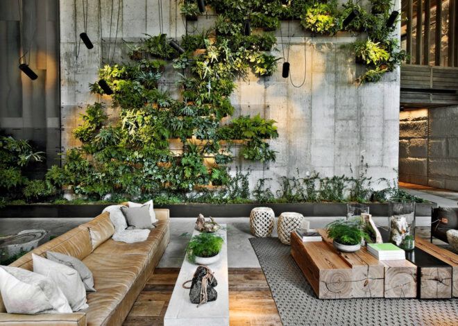 An outdoor sitting area framed by a large green wall of plants.
