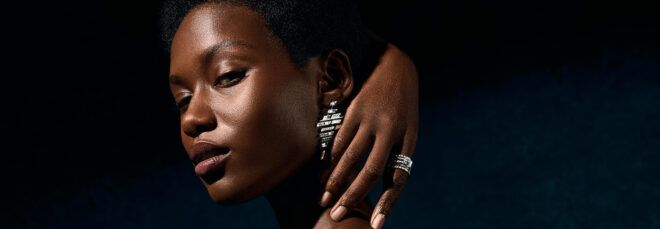 person wearing diamond ring and diamond earrings