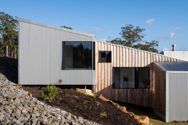 wood and metal home on a slope