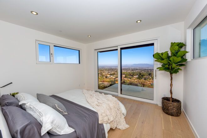 white and gray bed facing sliding glass doors