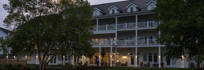 A three-story hotel facade with balconies and lights.