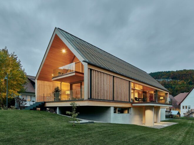 A side angle of the home, showing a concrete base on the lower level.