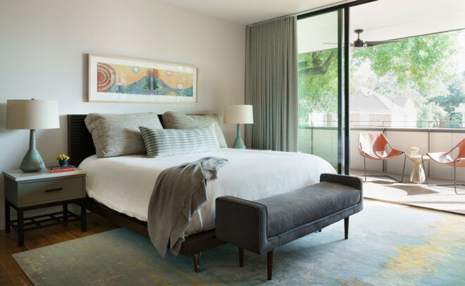 white and gray bedroom with glass wall opening to a balcony