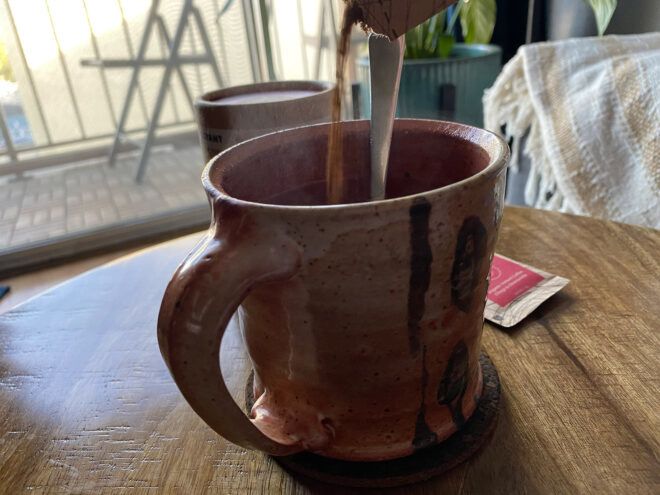 pouring instant coffee into a mug