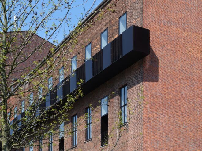 black mesh screen around balconies on a brick building