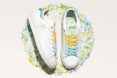 pile of shredded plastic around adidas sneakers with Tinkerbell design